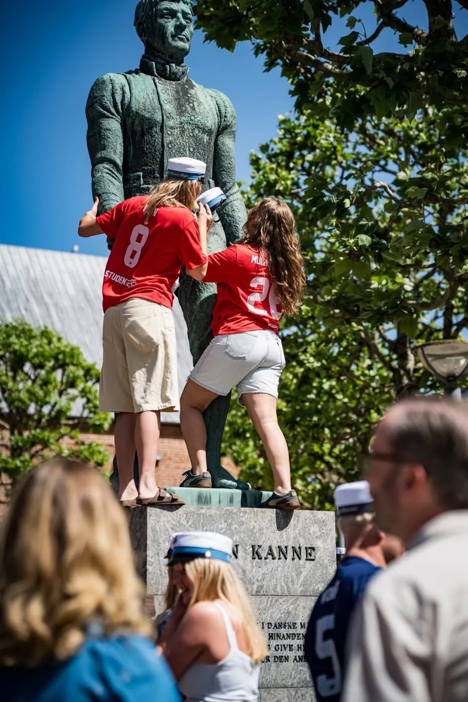 Studenter sætter en studenterhue på statuen af Søren Kanne på Torvet i Grenaa